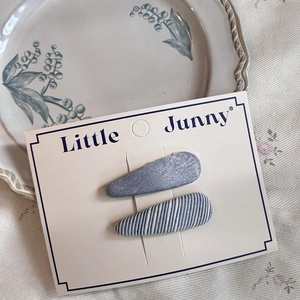 Close-up of blue plaid and glitter metal BB hair clips on a white card display