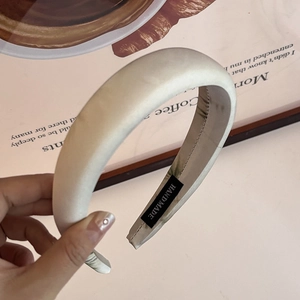 Close-up of champagne satin headband with handmade label and elegant silk texture