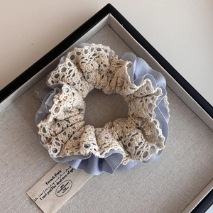 Elegant double-layered lace and blue chiffon scrunchie on a gray display tray