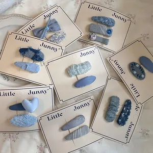 Close-up of blue fabric hair clip set featuring denim, tweed bows and heart shapes