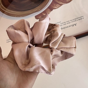 Detail of pink marble pattern scrunchie in soft satin fabric for hair styling