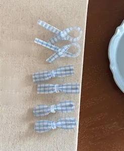 Detailed view of six blue and white checkered hair clips with subtle silver glitter finish