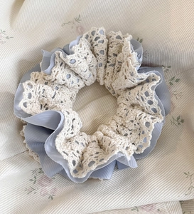 Close-up of dual-layer hair scrunchie with blue chiffon and beige crochet lace details