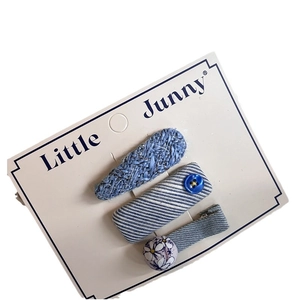 Three-piece set of blue plaid heart and bow hair clips on a white display card