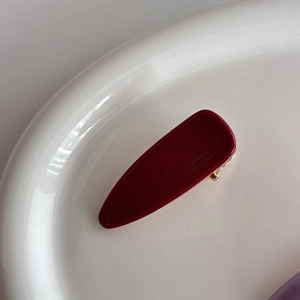Detailed close-up of dark red acetate hair clip with FRANCE Handmade engraving