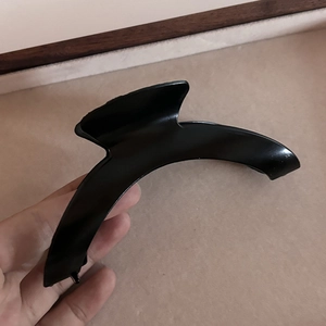 Pince à cheveux incurvée noire minimaliste avec finition lisse pour coiffure élégante