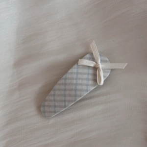 Pince à cheveux à carreaux de style français avec un nœud blanc sur fond de tissu doux