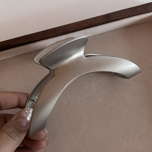 Pince à cheveux minimaliste en métal argent mat courbé avec texture antidérapante