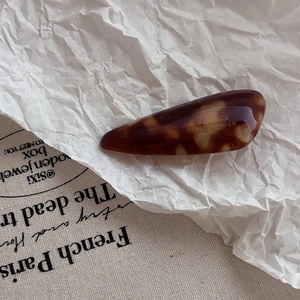 Close-up of tortoise shell pattern hair clip with gold France Handmade lettering