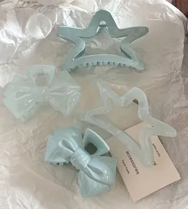 Detailed set of light blue star and bow hair clips with marble texture on white paper