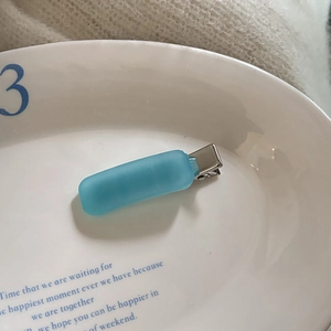 Macro view of light blue matte acetate hair clip with silver metal duckbill clamp