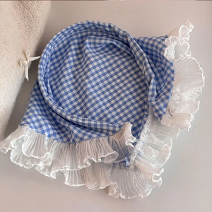 Dettaglio di foulard a quadretti blu e bianchi con bordo in pizzo in stile pastorale