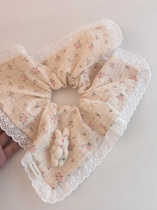 Détail d'un chouchou floral avec dentelle, breloque lapin en peluche et étiquette fait main