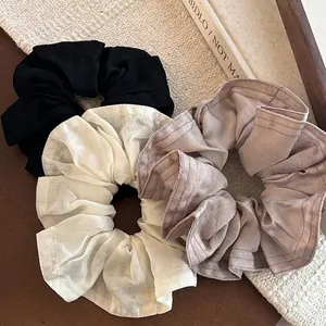 Chouchous en satin de style français en noir, crème et lavande sur fond épuré
