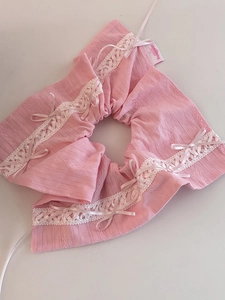Détail de chouchous en dentelle rose avec nœuds en soie et étiquette de design fait main