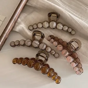 Brown pearl acrylic hair claw clip set for thick hair on white aesthetic fabric backdrop
