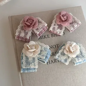 Detail of 3D lace camellia hair clip with rose petals and lace trim on vintage book