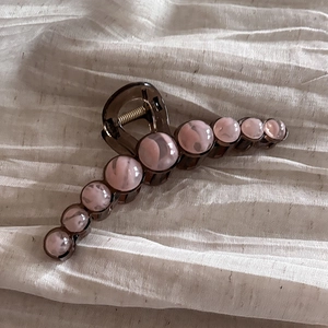 Close-up of coffee brown acrylic hair claw clip with pink marble beads and sturdy spring