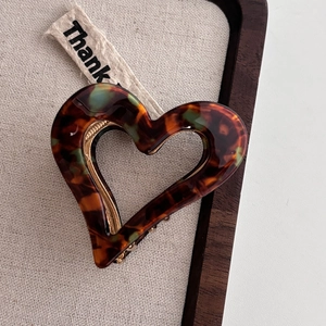 Elegant tortoise shell heart-shaped acetate hair claw clip with golden metal spring