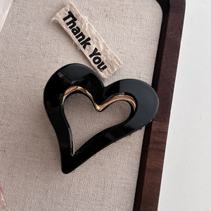 Elegant hollow heart acetate hair claw clip in black resin with gold metal teeth