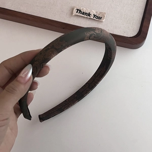 Gros plan sur le serre-tête marron vintage avec un élégant motif en tissu jacquard chinois