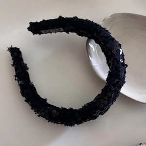 Elegant black sequin padded headband with tweed texture on a minimalist white background