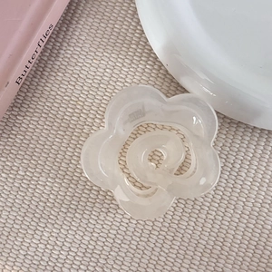 Vue macro d'une petite pince à cheveux fleur blanc crème au fini acrylique lisse