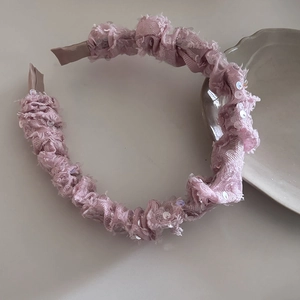 Detail shot of a pink sequined headband with pleated mesh fabric for a stylish hair accessory