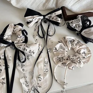 Detailed view of ink-wash calligraphy hair accessories including bows and scrunchies