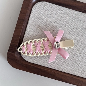 Detail of ballet style pink ribbon hair clip with cream enamel base and crystal gem