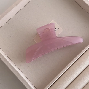 Detail of pink translucent matte hair claw clip on jewelry tray for styling