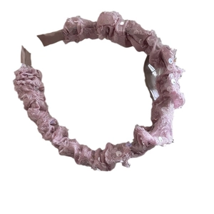 Sparkly pink sequin headband with ruched mesh texture and elegant top knot design