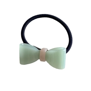 Green jelly acetate bow hair tie with pink center and elastic black rubber band