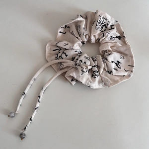 Ink style beige linen scrunchie with calligraphy print and long ribbon tails