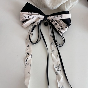 Detail of Chinese style bow hair clip with ink calligraphy ribbons and tassel