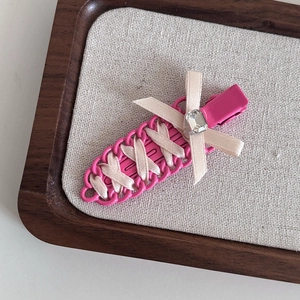 Detail of ballet style ribbon hair clip with rose pink frame and beige bow center