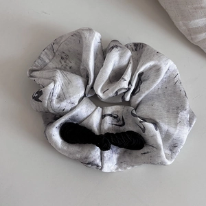 Detail of silk hair scrunchie with Chinese ink calligraphy and handmade frog button