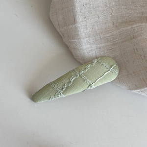 Détail de la pince à cheveux en tissu jacquard vert clair avec nœud en dentelle