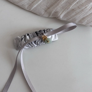 Detail of silk ink-wash hair ribbon with faux jade pendant and gold metal hardware