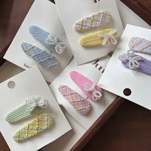 Close-up of girls' plaid tweed hair clips and velvet pearl bow sets in various colors
