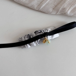 Detailed view of Ink Painting hair ribbon with gold Fu charm and green jade pendant