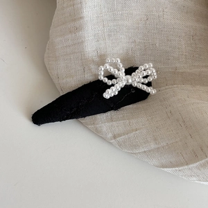 Gros plan d'une pince à cheveux en tissu jacquard avec un nœud en perles élégant