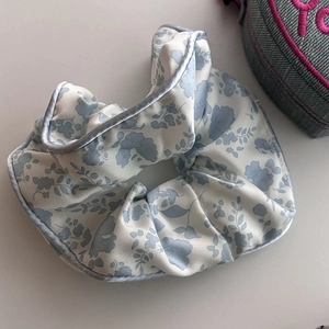 Eleganter hellblauer Seiden-Scrunchie mit Blumenmuster und weicher Satin-Textur