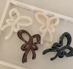 Détails de grandes pinces à cheveux papillon en quatre couleurs sur un plateau blanc
