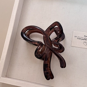 Grande pince à cheveux papillon écaille de tortue minimaliste sur un plateau blanc