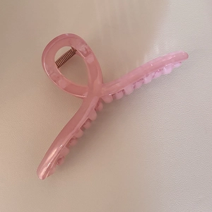 Pince à cheveux rose translucide effet gelée pour femme avec design torsadé épuré