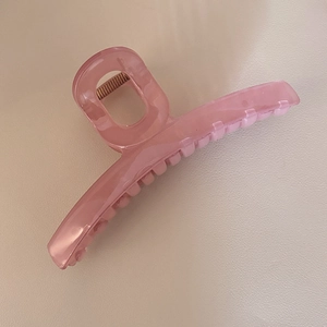Vue détaillée d'une grande pince à cheveux rose translucide en résine effet gelée