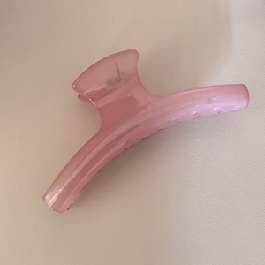 Vue détaillée d'une grande pince à cheveux rose effet gelée pour coiffure élégante