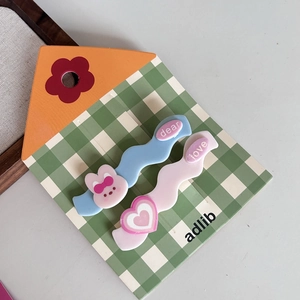 Detail view of colorful acrylic wavy hair clips with cute rabbit and heart motifs
