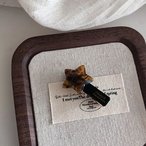 Star shaped acetate hair clip with tortoise shell pattern and handmade gold lettering